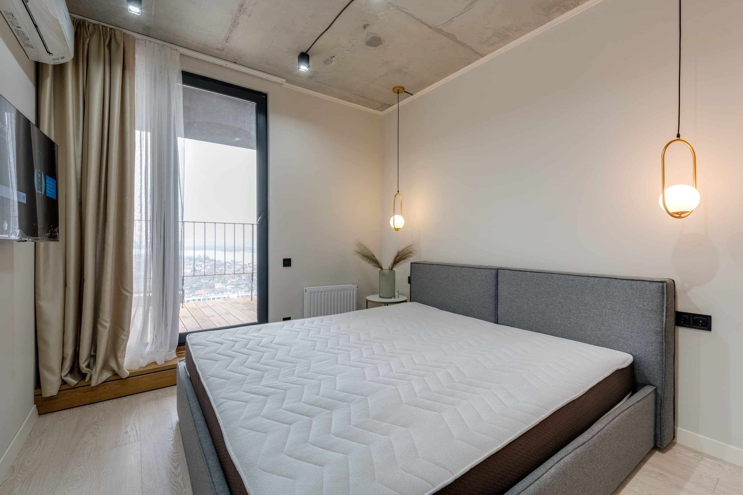 A clean mattress on a bed in a bright, modern bedroom