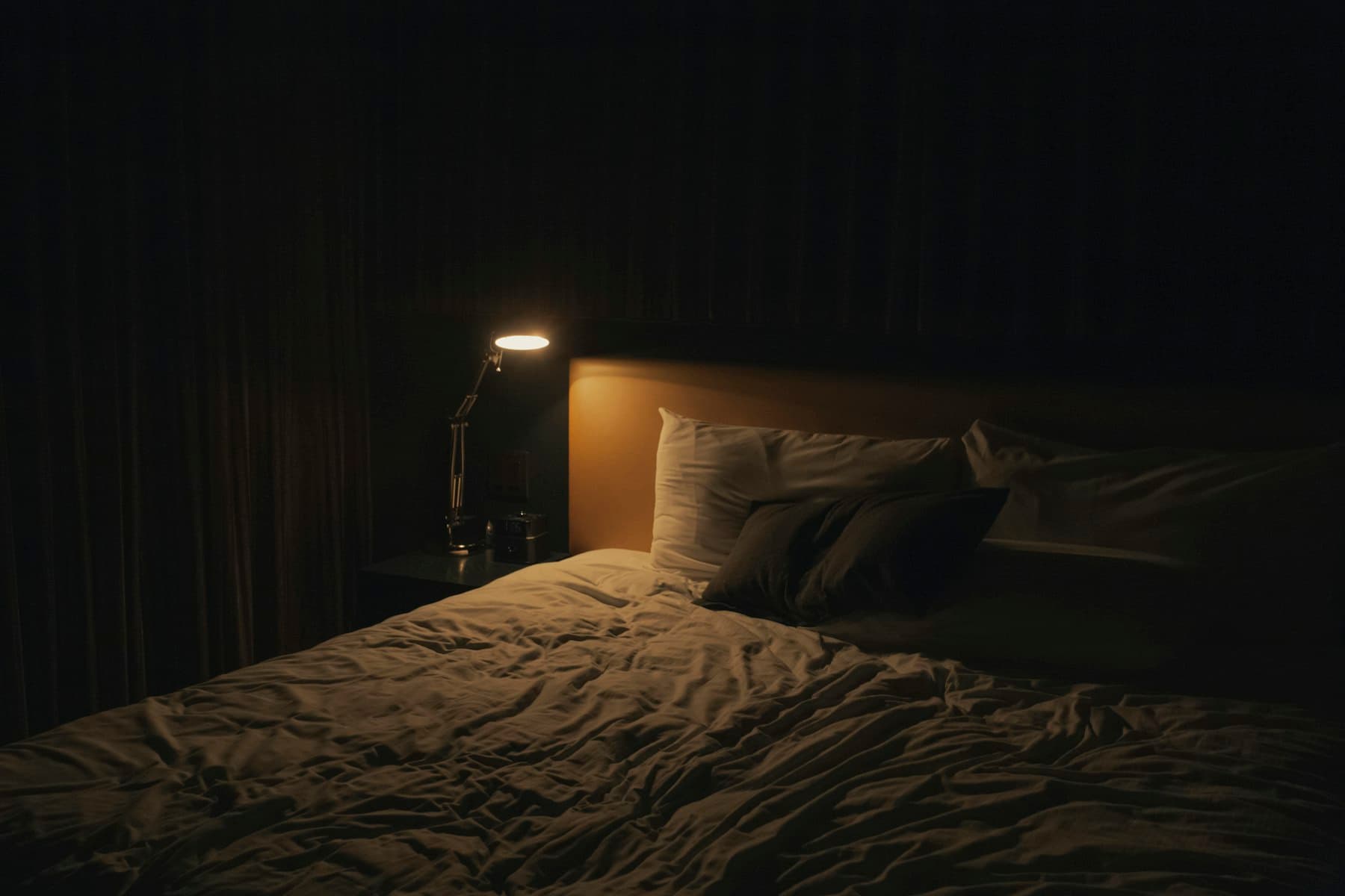 A made bed with a clean mattress in a bright bedroom.